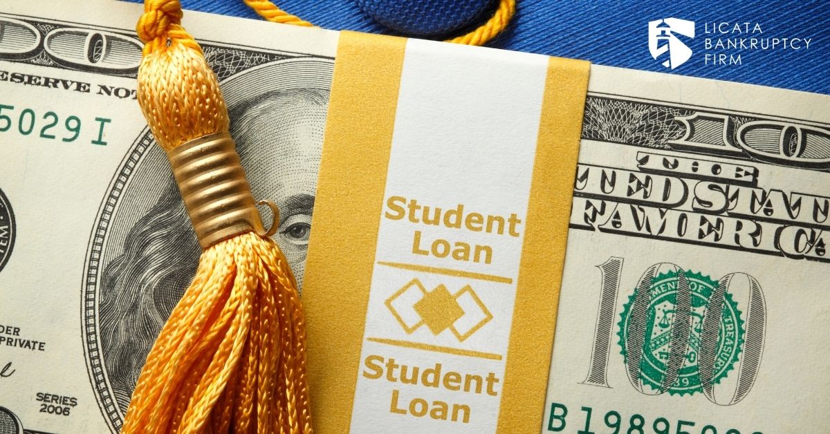 Money with paper wrap that says "student loan" around it and graduation tassel